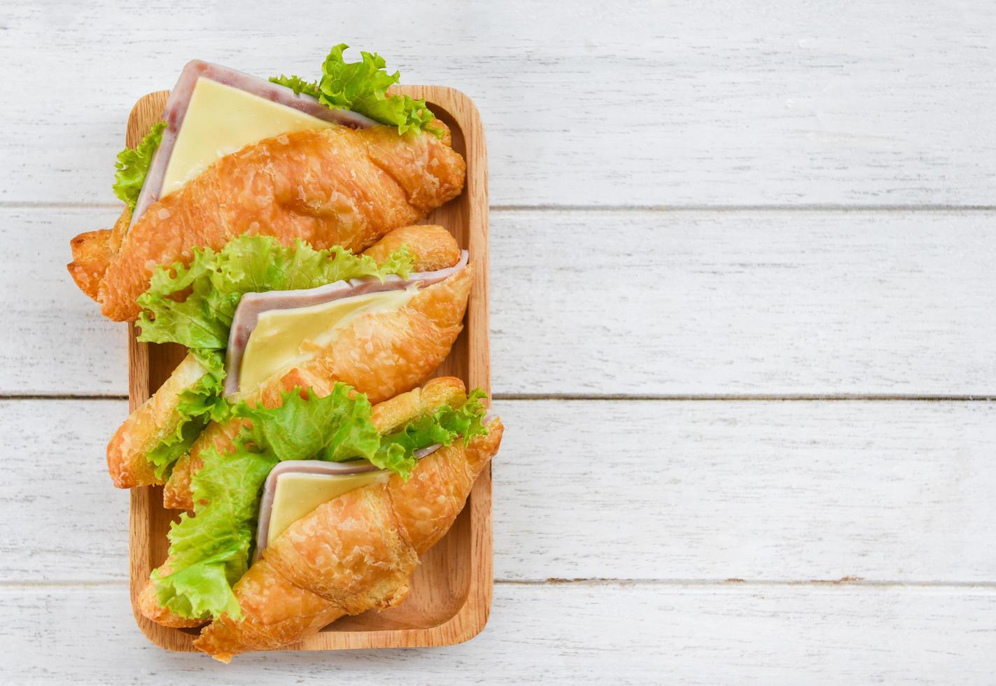 croissant sandwiches on wooden table , top view - croissant salad ham vegetable photo