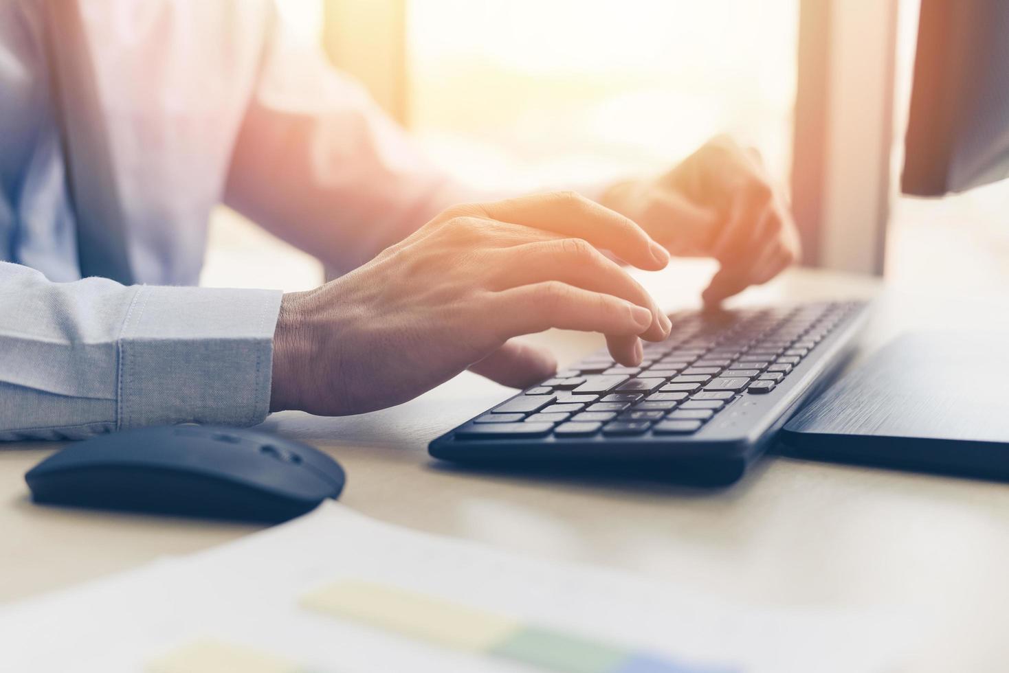 Businessman working on keyboard and mouse computer man sitting on the table and using internet technology at workplace in office - Close up of typing male hand on keyboard concept photo
