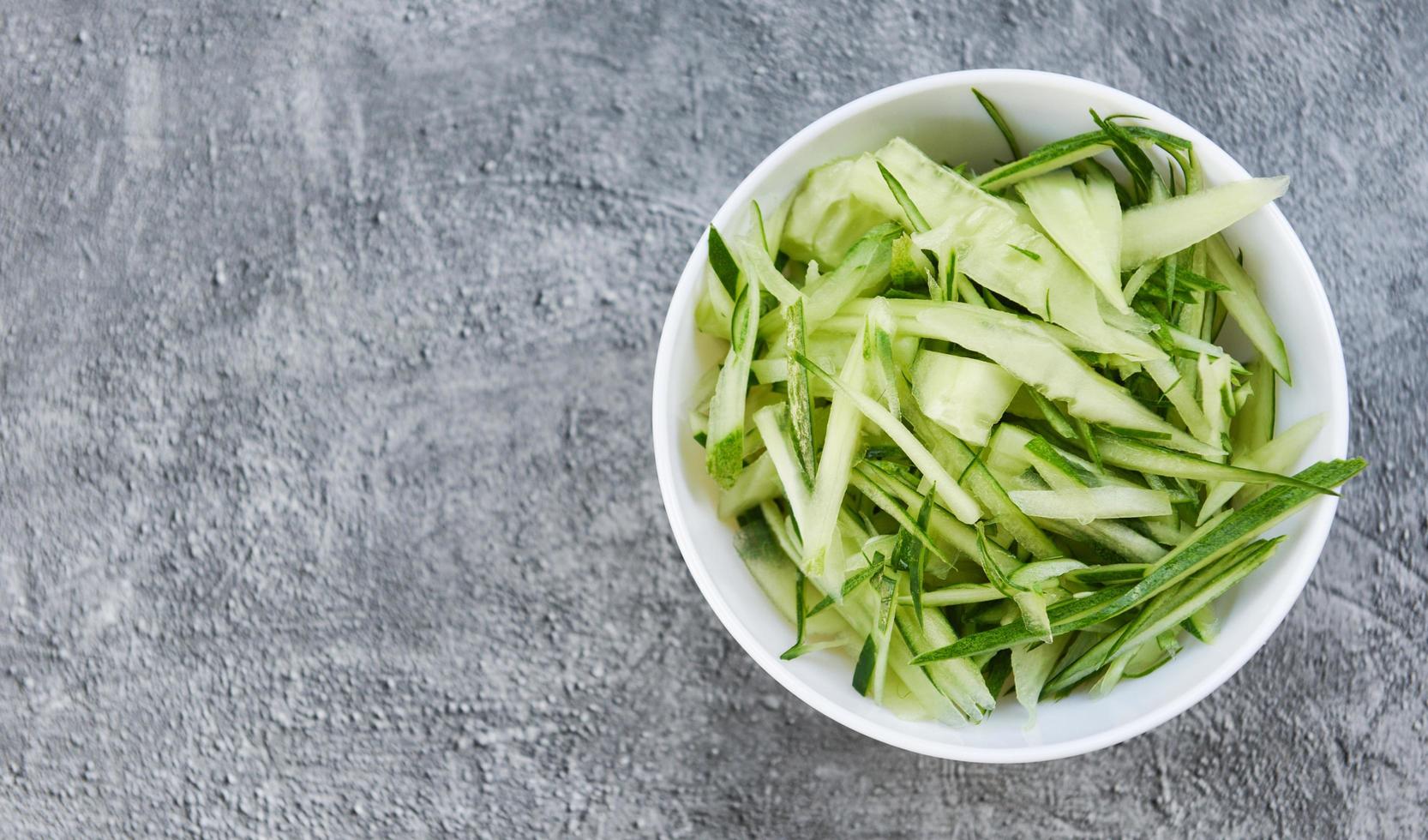 Cucumber slice on white bowl , top view - shredded cucumber sliced for salad or cooking food photo