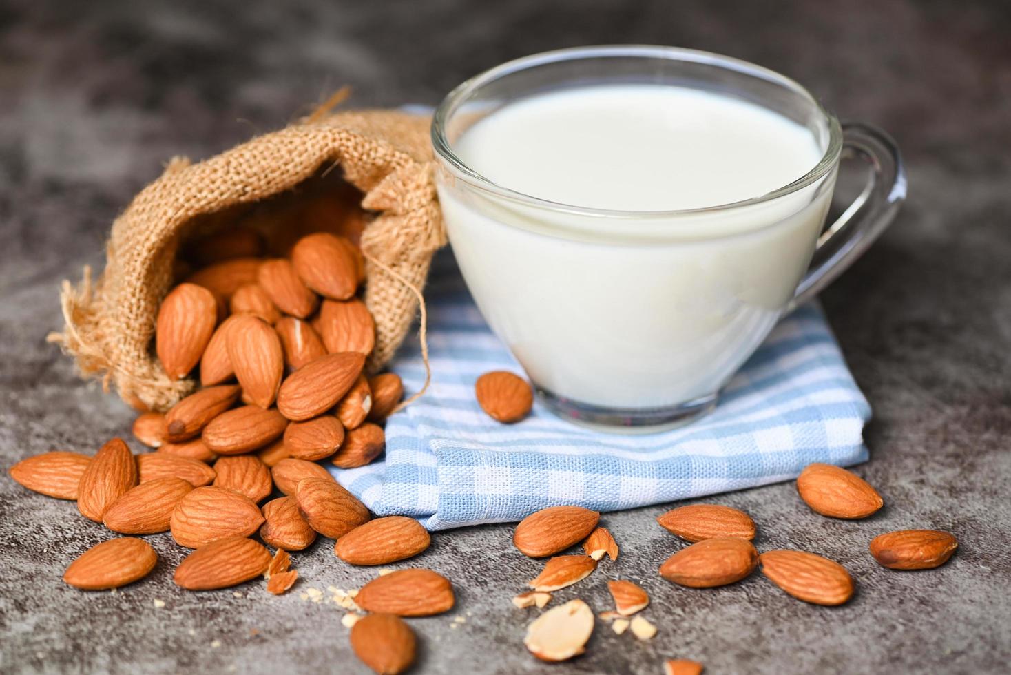 Almond milk and Almonds nuts on on sack background, Delicious sweet almonds on the table, roasted almond nut for healthy food and snack photo