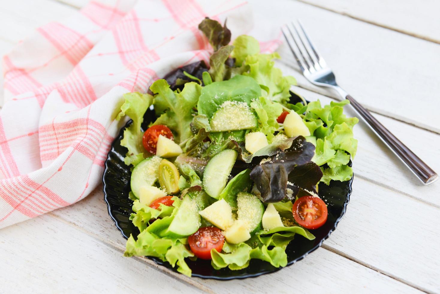 Healthy salad vegetable leaves mix salad with fruit and fresh lettuce tomato cucumber on plate on table fresh food eating photo