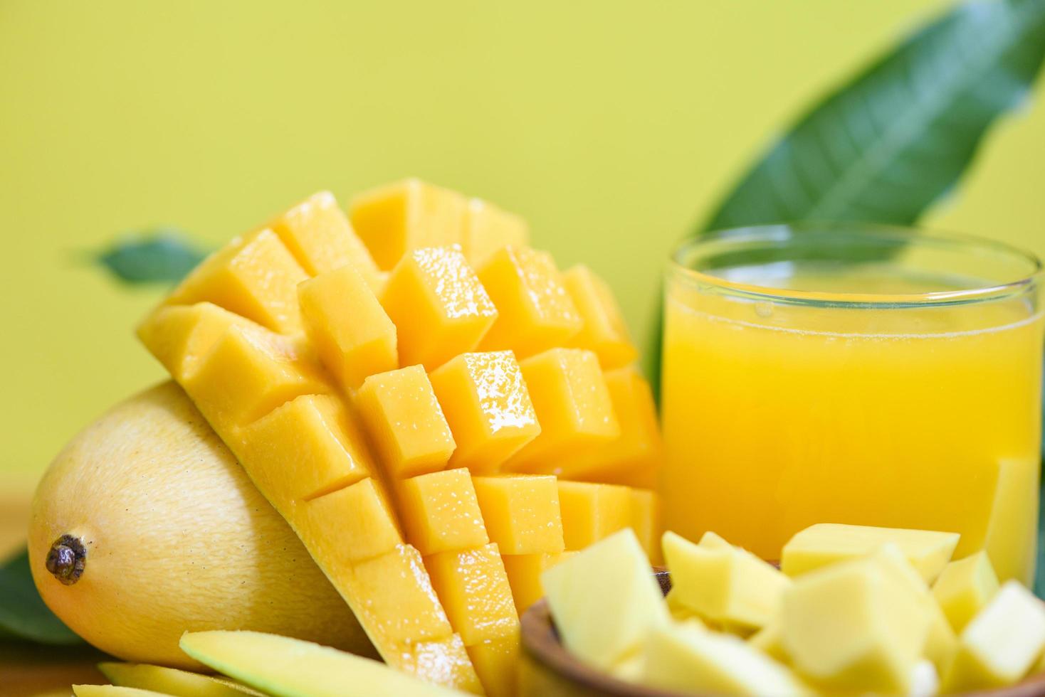 vaso de jugo de mango con rebanada de mango en hojas de mango del concepto de fruta de verano tropical de árbol - mangos maduros dulces foto