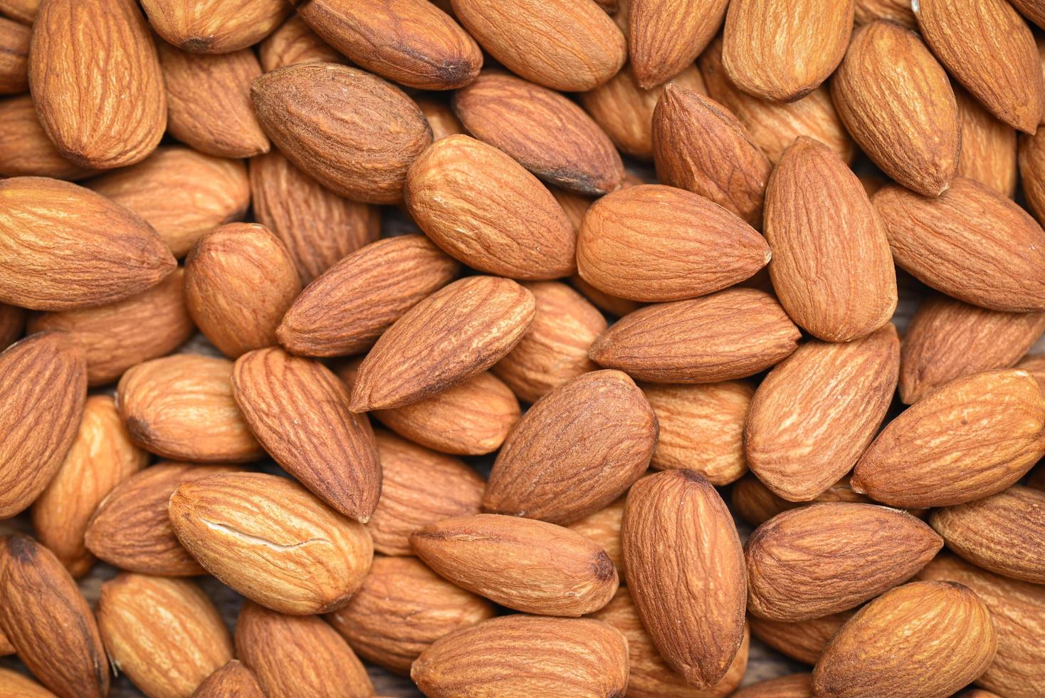 Almonds nuts on background, Close up delicious sweet almonds top view, roasted almond nut for healthy food and snack photo
