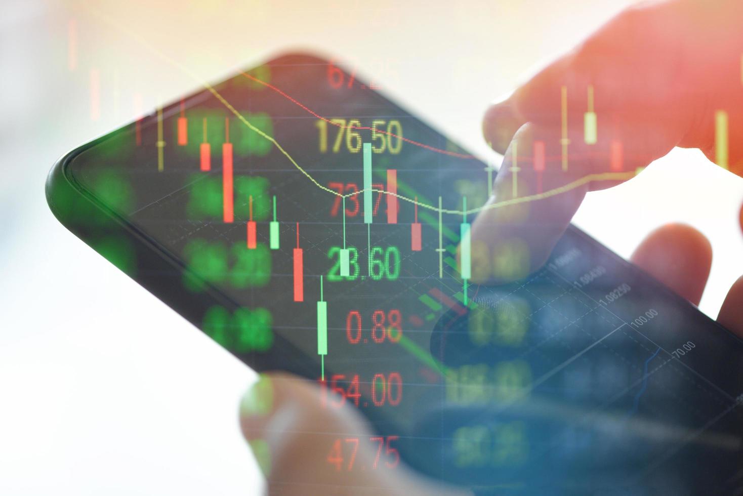 Trading stock graph or forex online with application on smartphone - Businessman trading stocks chart with statistic analysis price table market financial on mobile phone finance data and technology photo