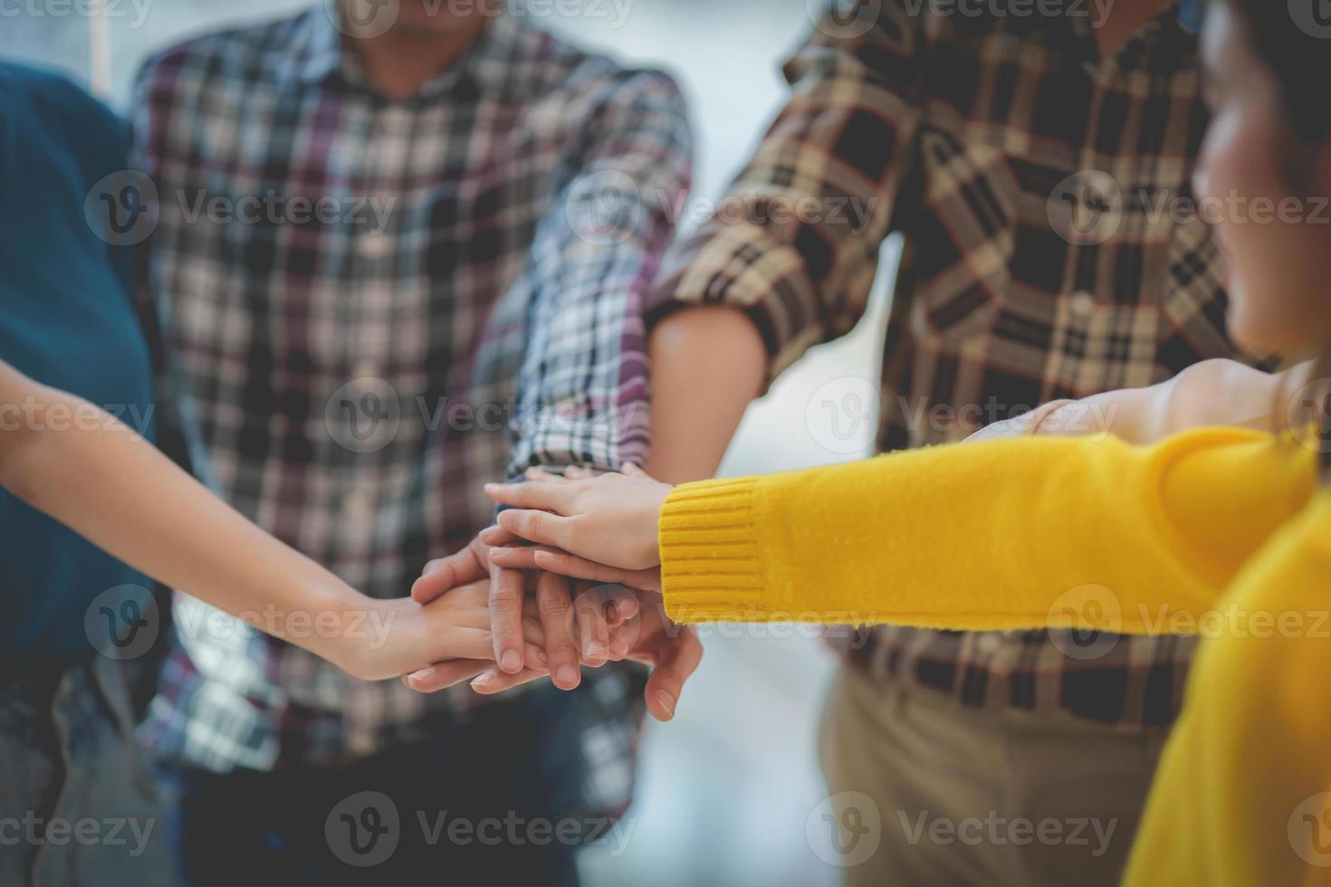Group of Multiracial people putting their hands working together showing oneness symbol. photo