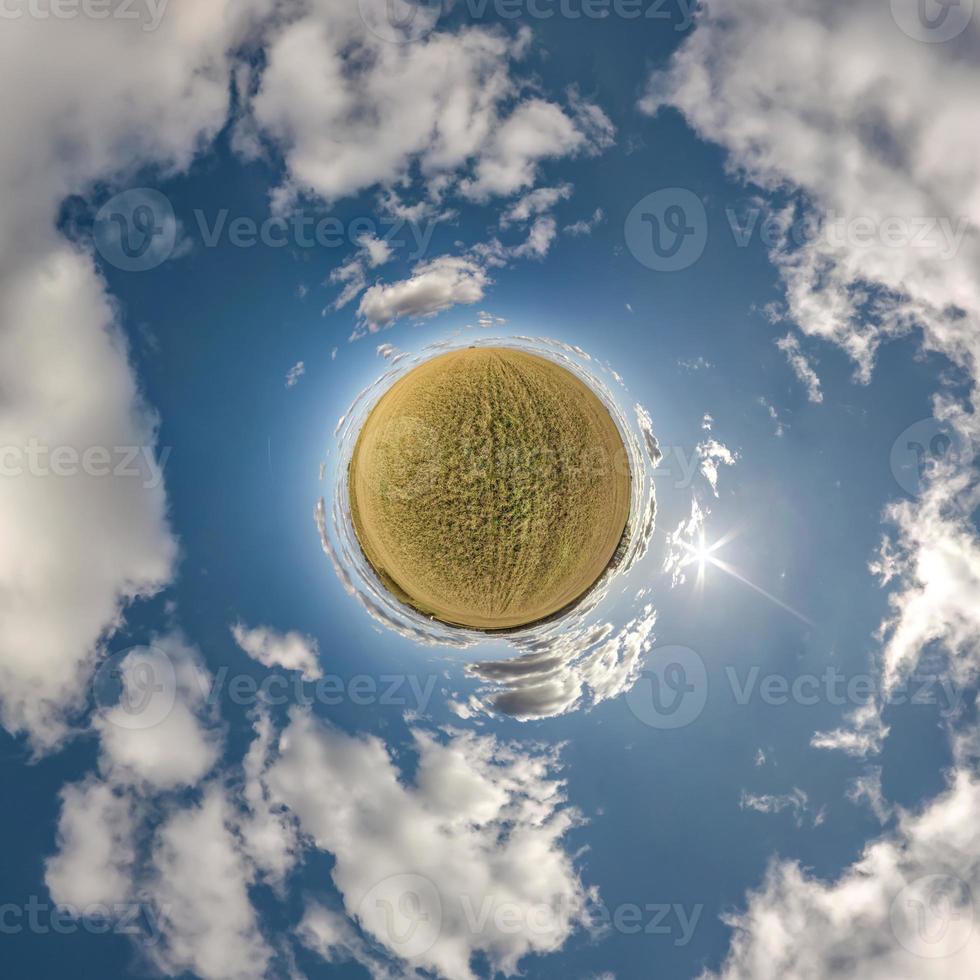 tiny planet in blue sky with beautiful clouds. Transformation of spherical panorama 360 degrees. Spherical abstract aerial view. Curvature of space. photo