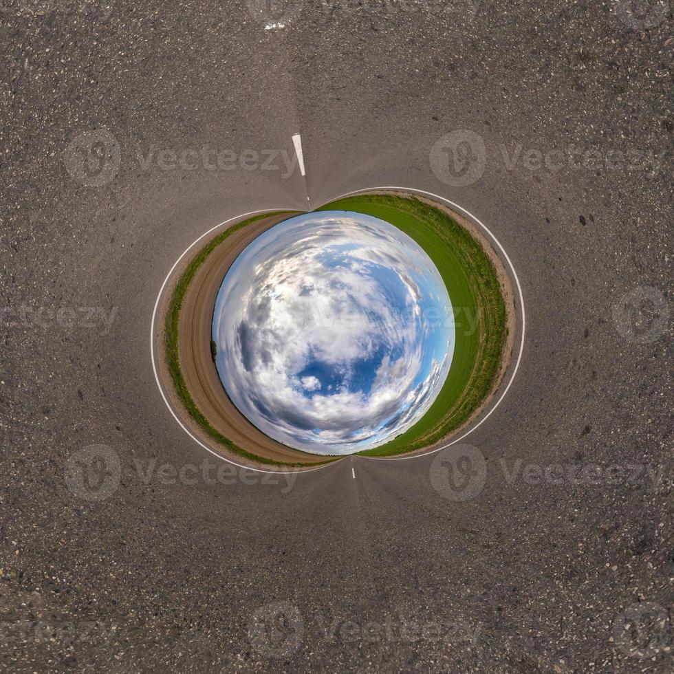 Inversion of blue little planet transformation of spherical panorama 360 degrees. Spherical abstract aerial view on road with awesome beautiful clouds. Curvature of space. photo