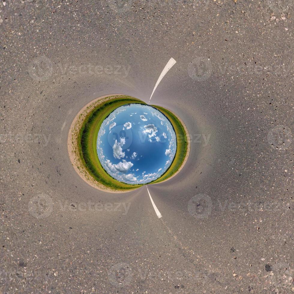 blue sky ball in middle of swirling asphalt road or field. Inversion of tiny planet transformation of spherical panorama 360 degrees. Spherical abstract view. Curvature of space. photo