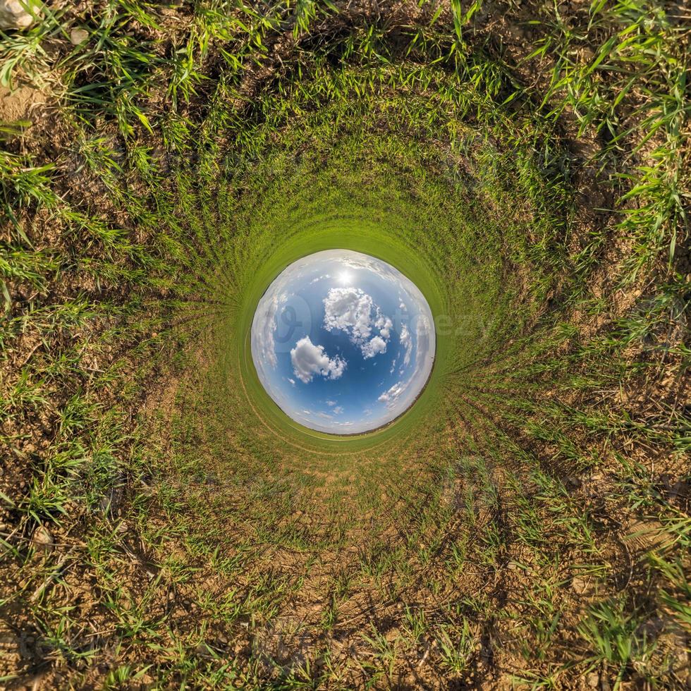 blue sky ball in middle of swirling asphalt road or field. Inversion of tiny planet transformation of spherical panorama 360 degrees. Spherical abstract view. Curvature of space. photo