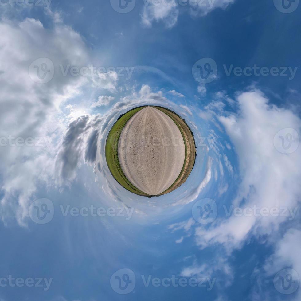 tiny planet in blue sky with sun and beautiful clouds. Transformation of spherical panorama 360 degrees. Spherical abstract aerial view. Curvature of space. photo