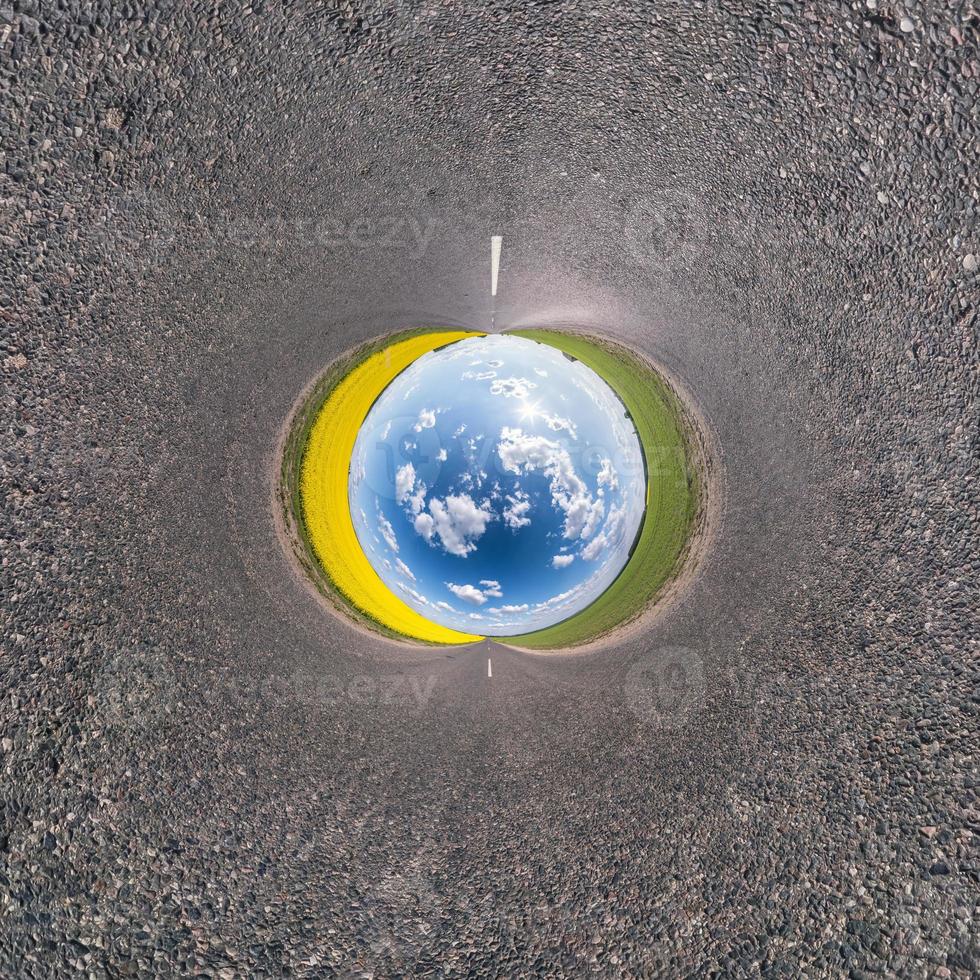 blue sky ball in middle of swirling asphalt road or field. Inversion of tiny planet transformation of spherical panorama 360 degrees. Spherical abstract view. Curvature of space. photo