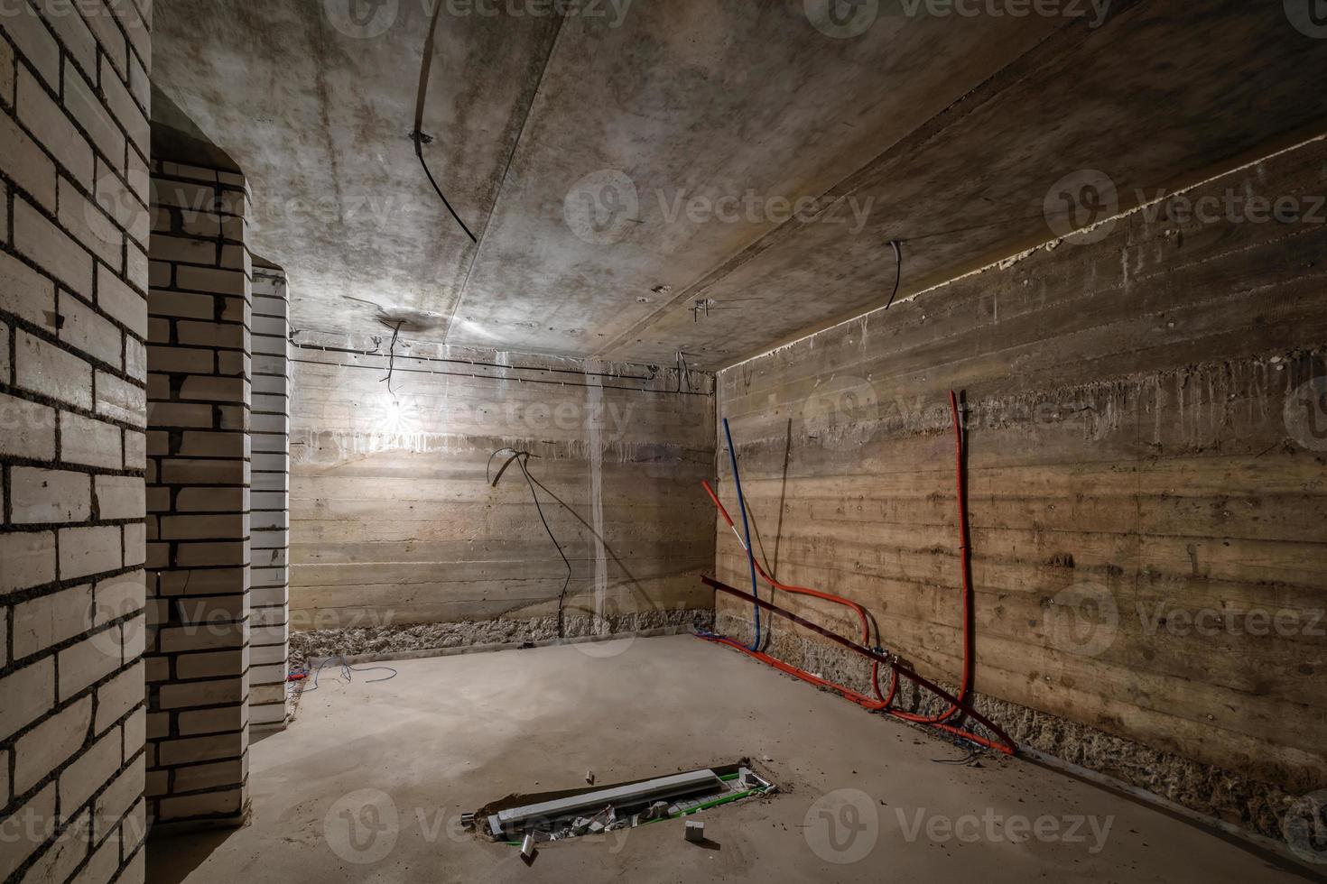 Empty unfurnished basement room with minimal preparatory repairs. interior with white brick walls photo