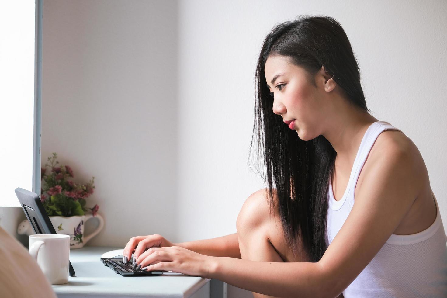 new normal, a businesswoman using  computer to work for a company Via the internet on your desk at home. photo