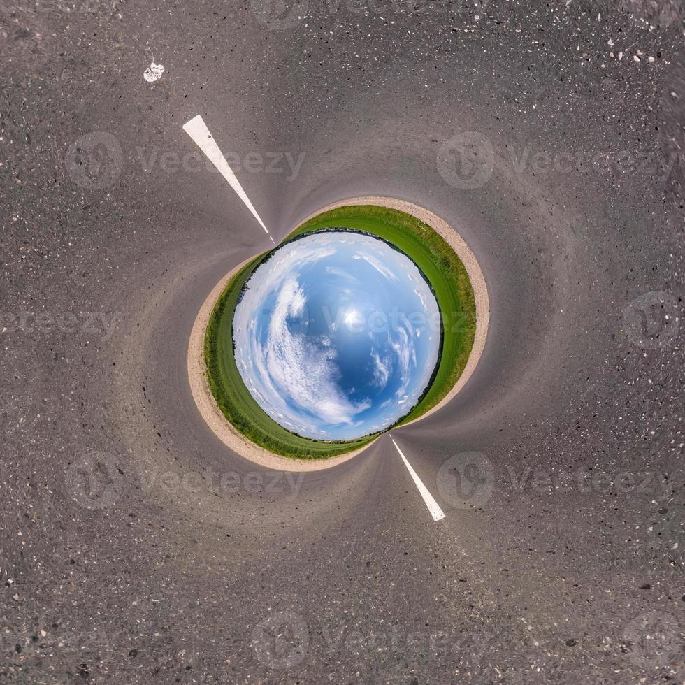 Blue little planet on asphalt road. Inversion of tiny planet transformation of spherical panorama 360 degrees. Spherical abstract aerial view. Curvature of space. photo