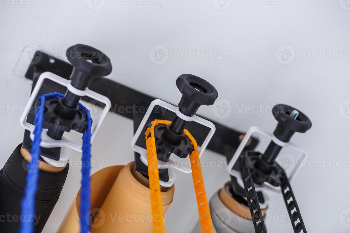 mounting manual support system for photo backdrops in modern studio. Rolls of colorful paper backgrounds for photo studio hang on the wall