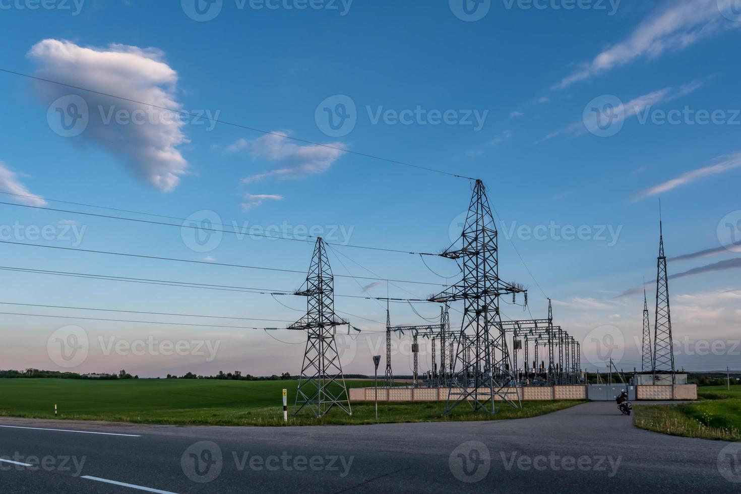 Silhouette of the high voltage electric pylon towers on the background of beautiful evening clouds photo