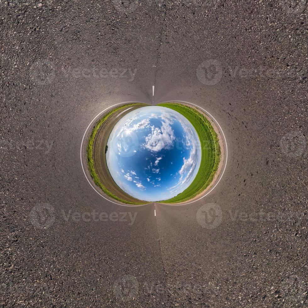 Inversion of blue little planet transformation of spherical panorama 360 degrees. Spherical abstract aerial view on road with awesome beautiful clouds. Curvature of space. photo