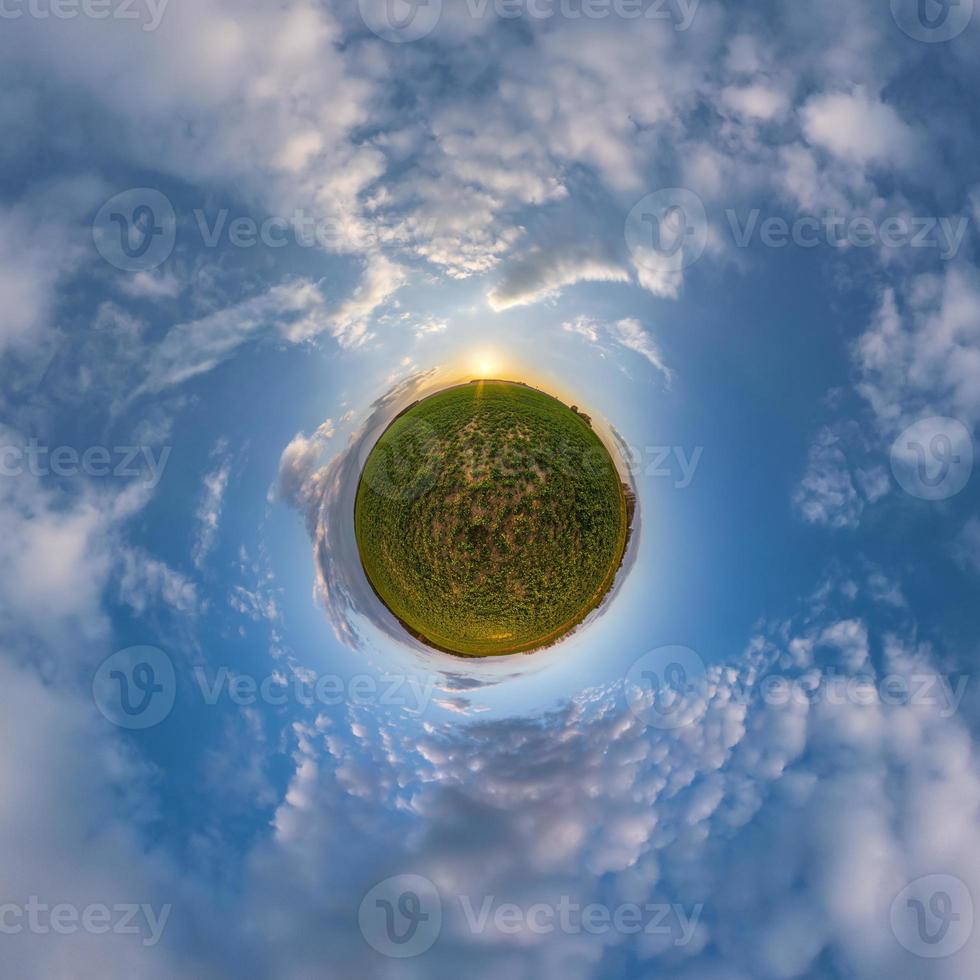tiny planet in blue evening sky with beautiful clouds. Transformation of spherical panorama 360 degrees. Spherical abstract aerial view. Curvature of space. photo