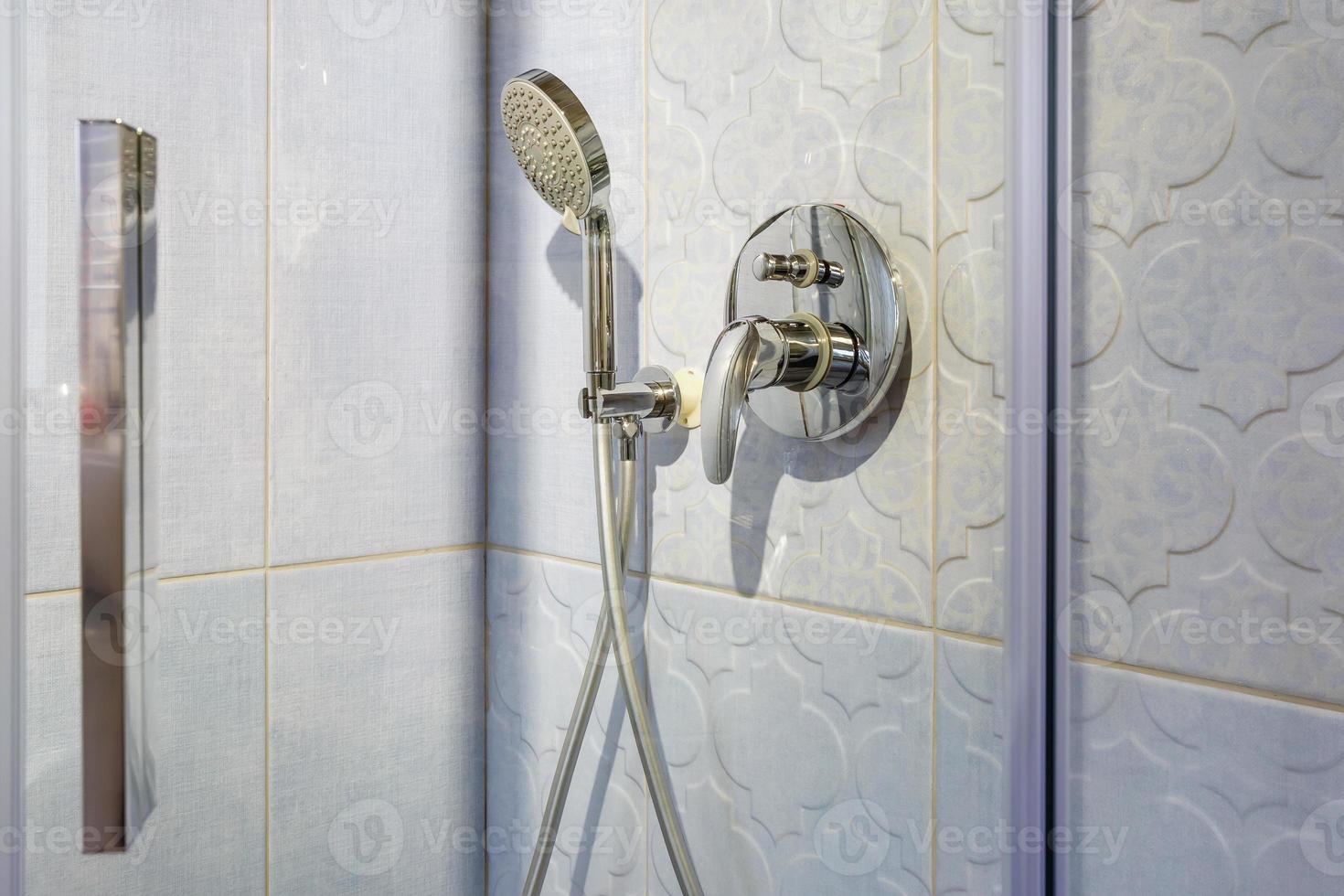 water tap sink with faucet in expensive loft bathroom. detail of a corner shower cabin with wall mount shower attachment photo