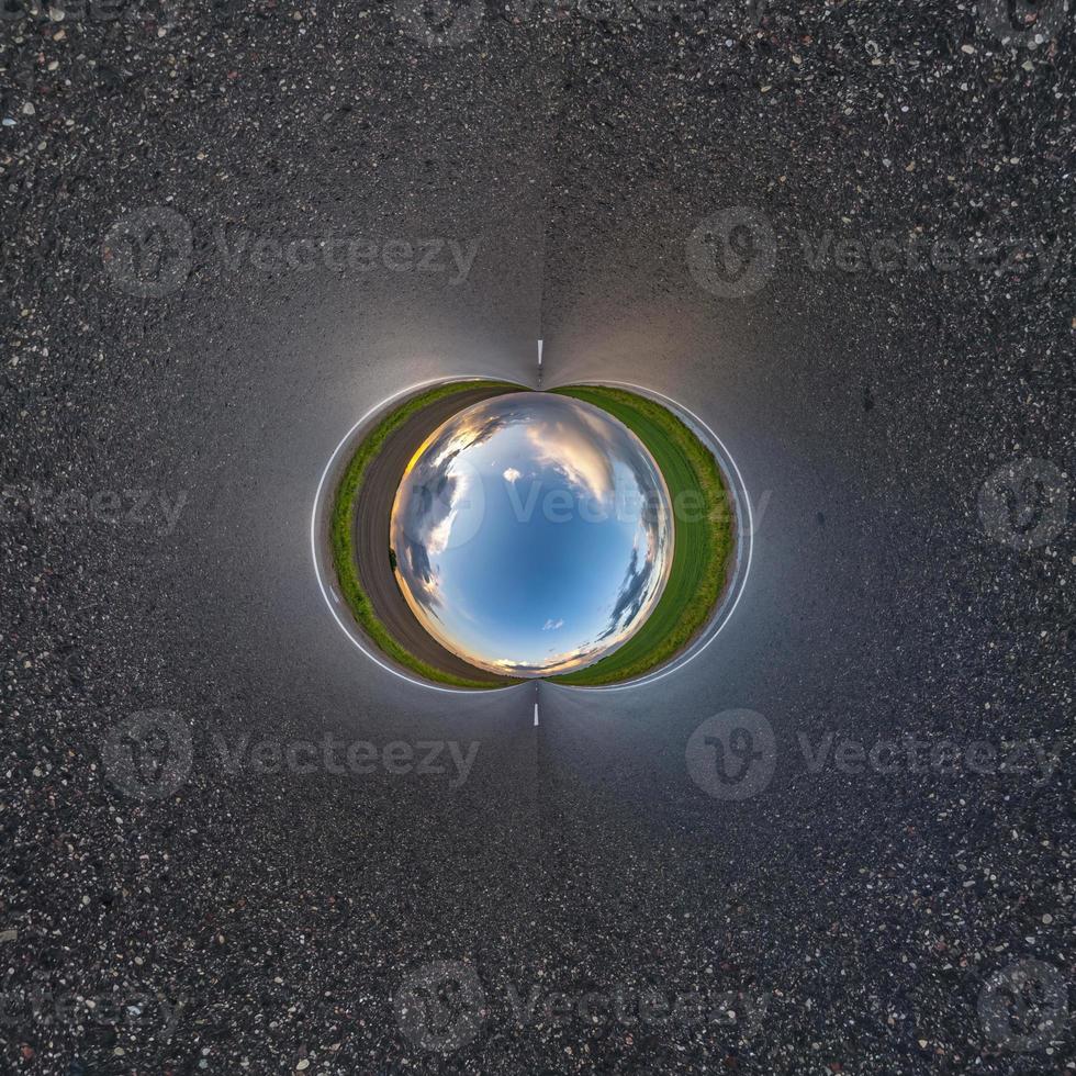 bola de cielo azul en medio de una carretera o campo de asfalto giratorio. inversión de la transformación del pequeño planeta del panorama esférico de 360 grados. vista abstracta esférica. curvatura del espacio. foto