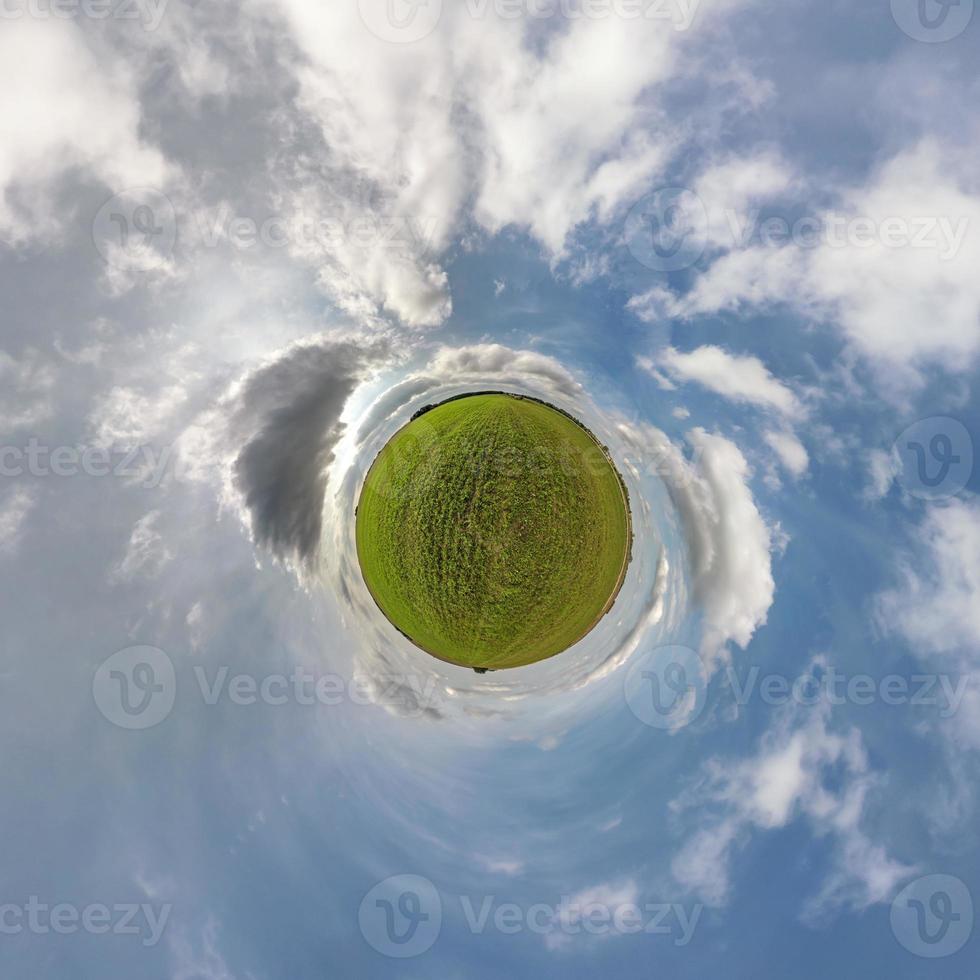 tiny planet in blue sky with beautiful clouds. Transformation of spherical panorama 360 degrees. Spherical abstract aerial view. Curvature of space. photo