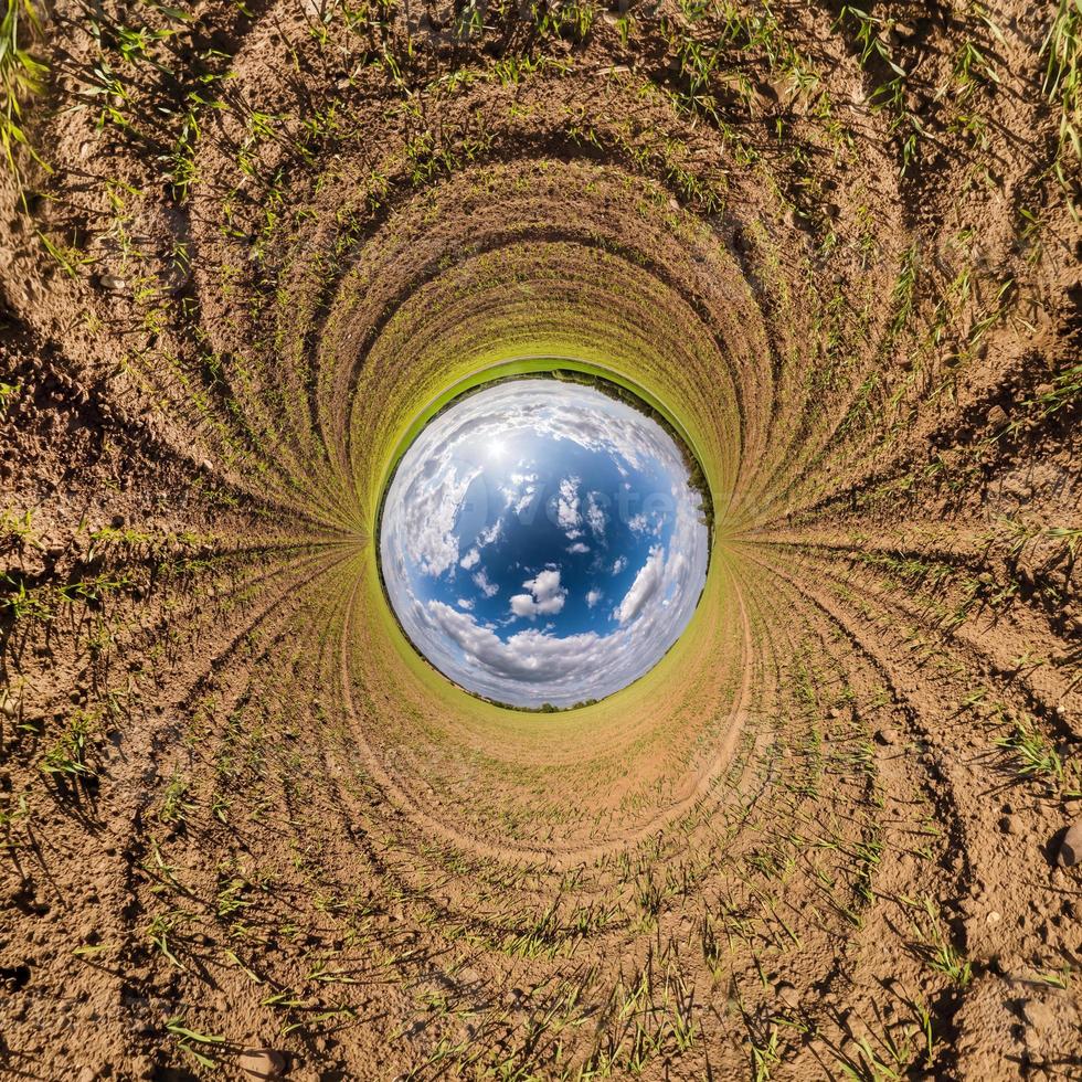Inversion of blue little planet transformation of spherical panorama 360 degrees. Spherical abstract aerial view on road with awesome beautiful clouds. Curvature of space. photo