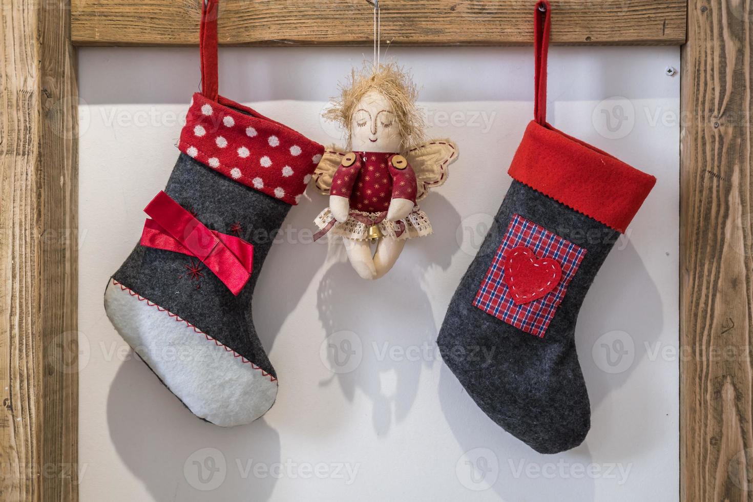 toy angel and christmas bots hanging waiting for new year gifts in wooden frame photo