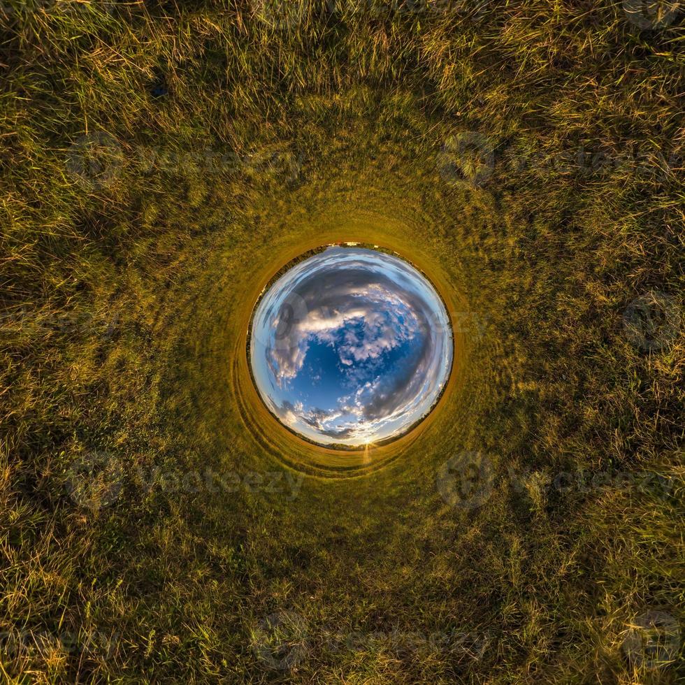 Inversion of little planet transformation of spherical panorama 360 degrees. Spherical abstract aerial view on field with awesome beautiful clouds. Curvature of space. photo