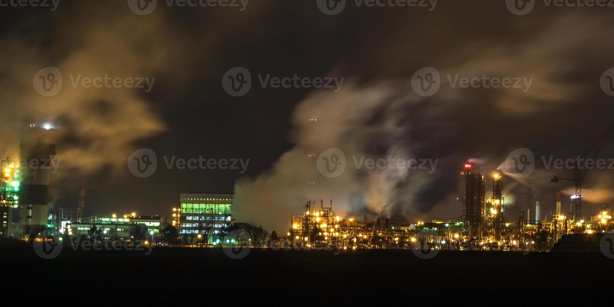 night industrial landscape environmental pollution waste of thermal power plant. Big pipes of chemical industry enterprise plant photo