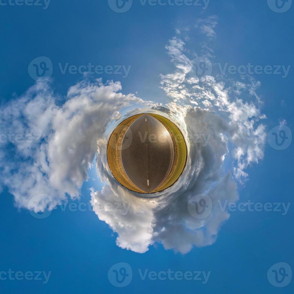 tiny planet in blue sky with beautiful clouds. Transformation of spherical panorama 360 degrees. Spherical abstract aerial view. Curvature of space. photo