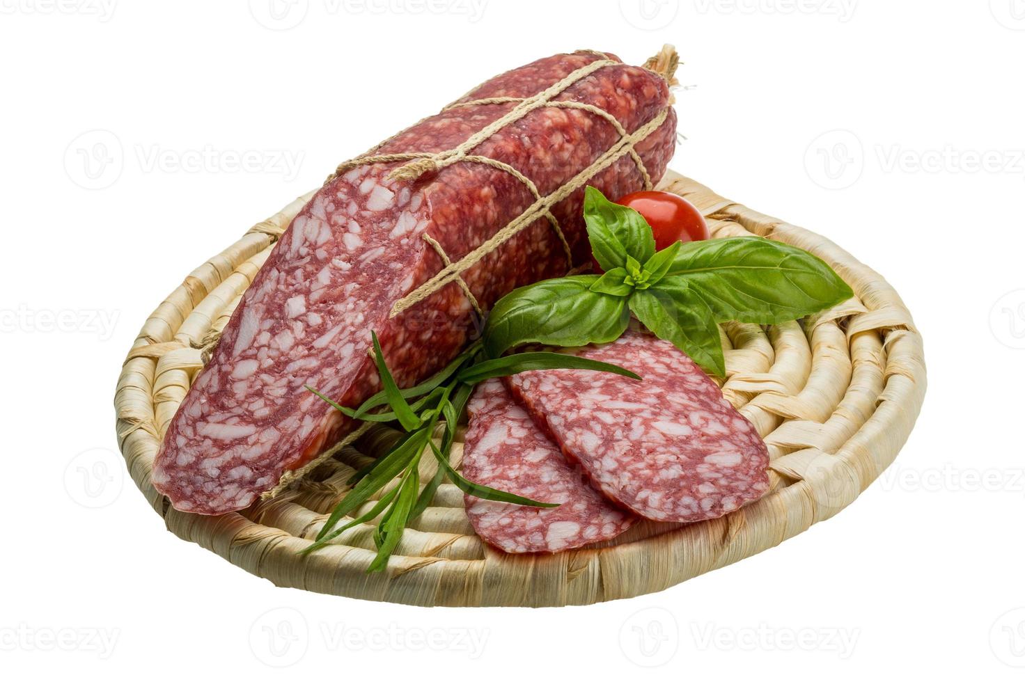 salami en placa de madera y fondo blanco. foto