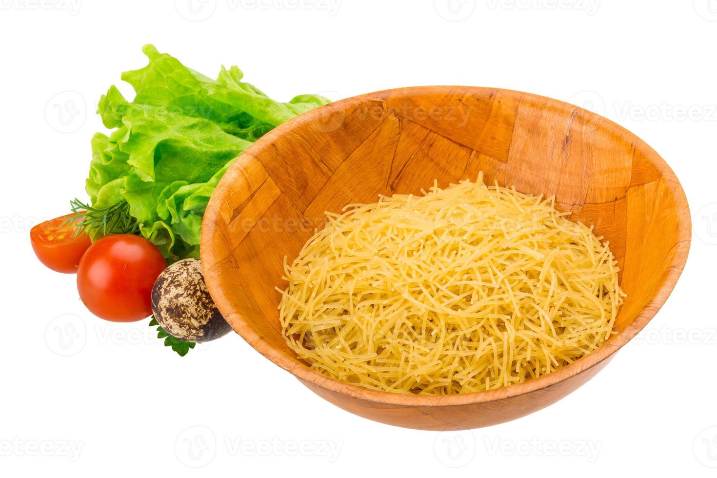 Raw pasta in a bowl on white background photo