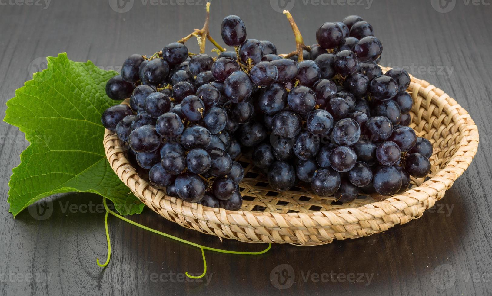 Grape in a basket on wooden background photo