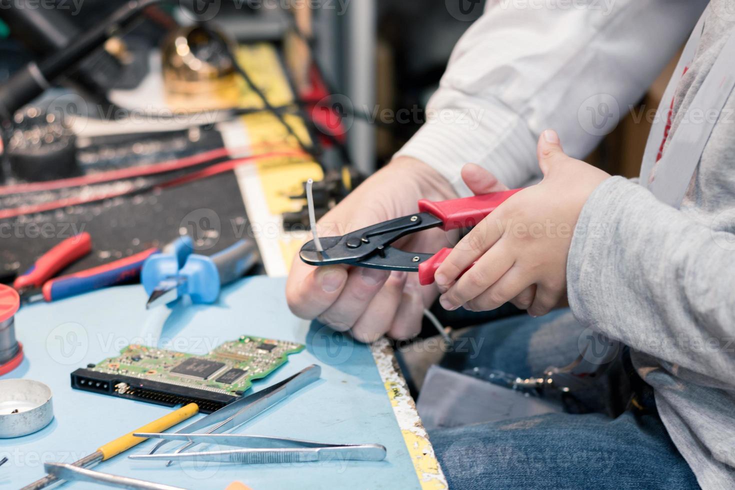 Close up of cutting wire with pliers in engineering laboratory. photo