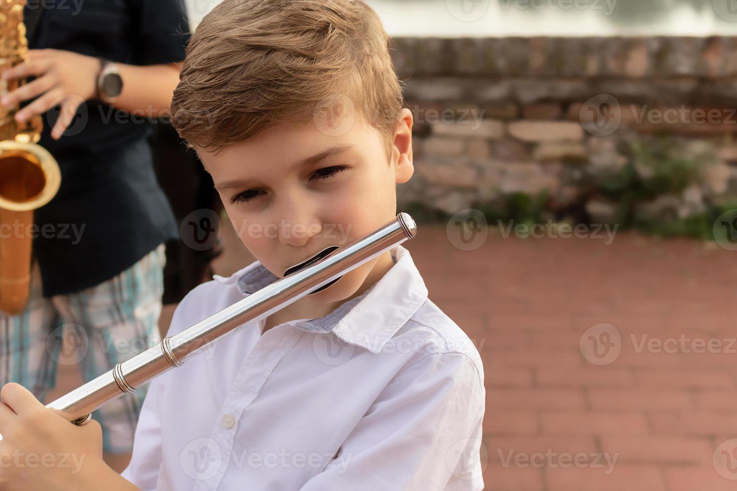 Small boy playing music on a flute. photo