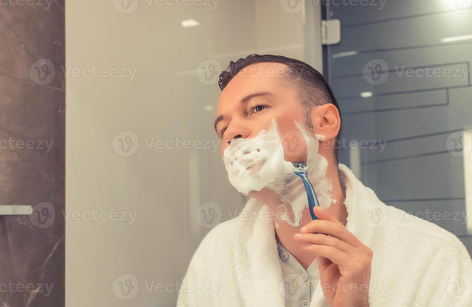 Mid adult man shaving in the bathroom. photo