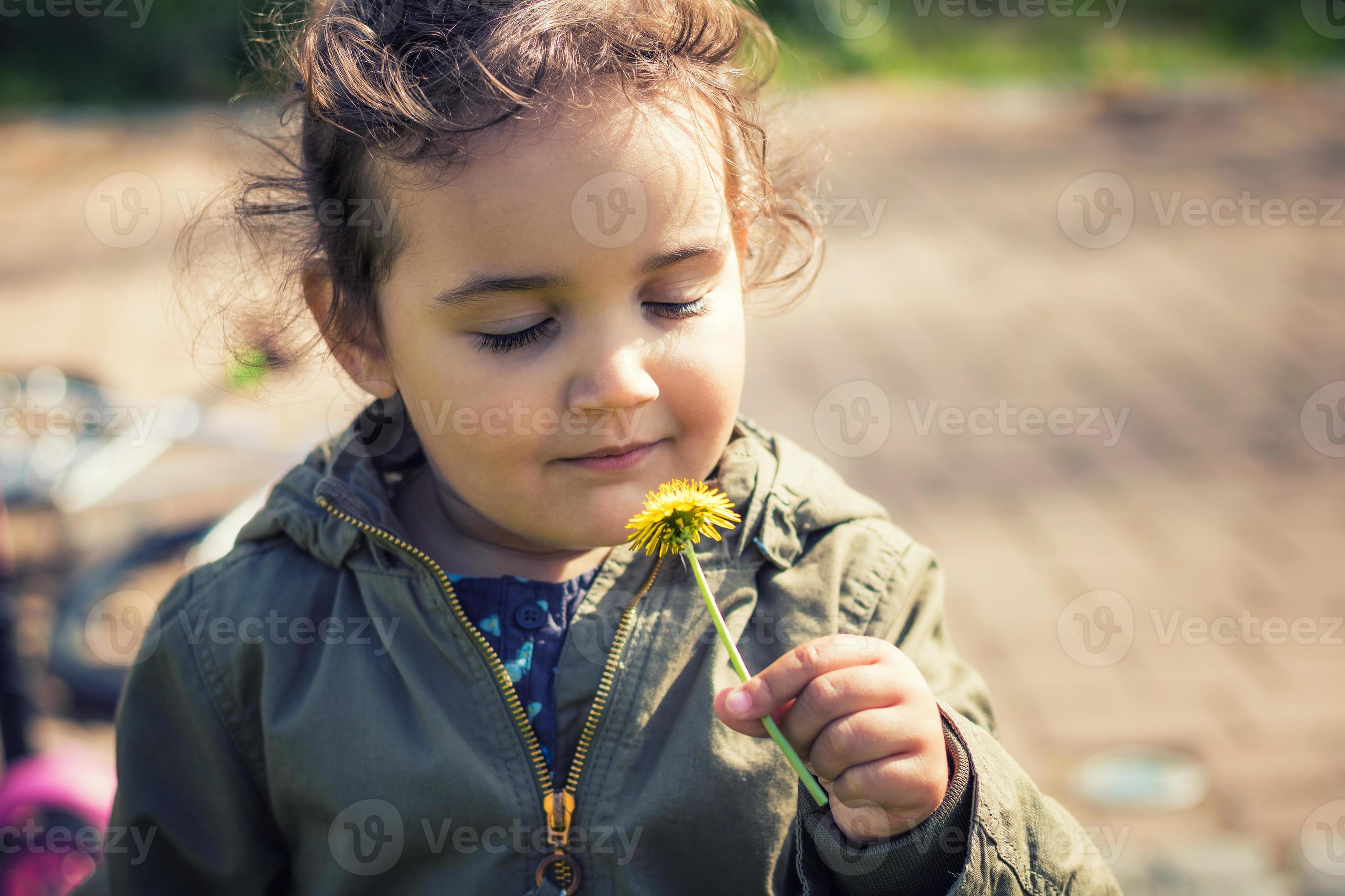 Cute girl smelling flower with eyes closed. 10908787 Stock Photo at