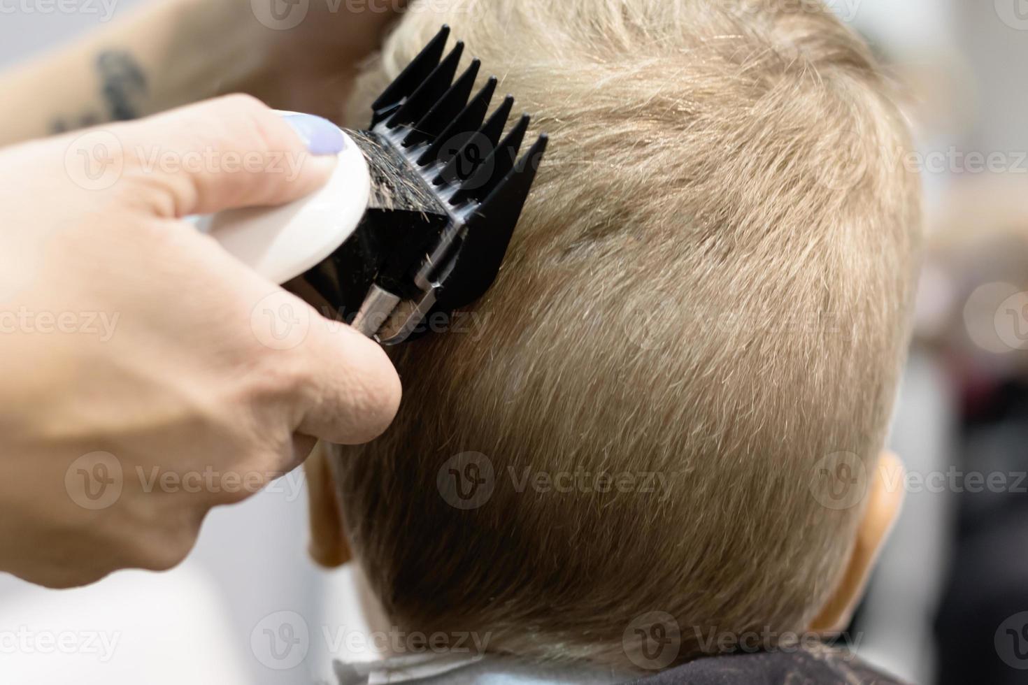 Close-up of haircut of a boy at barber shop. photo