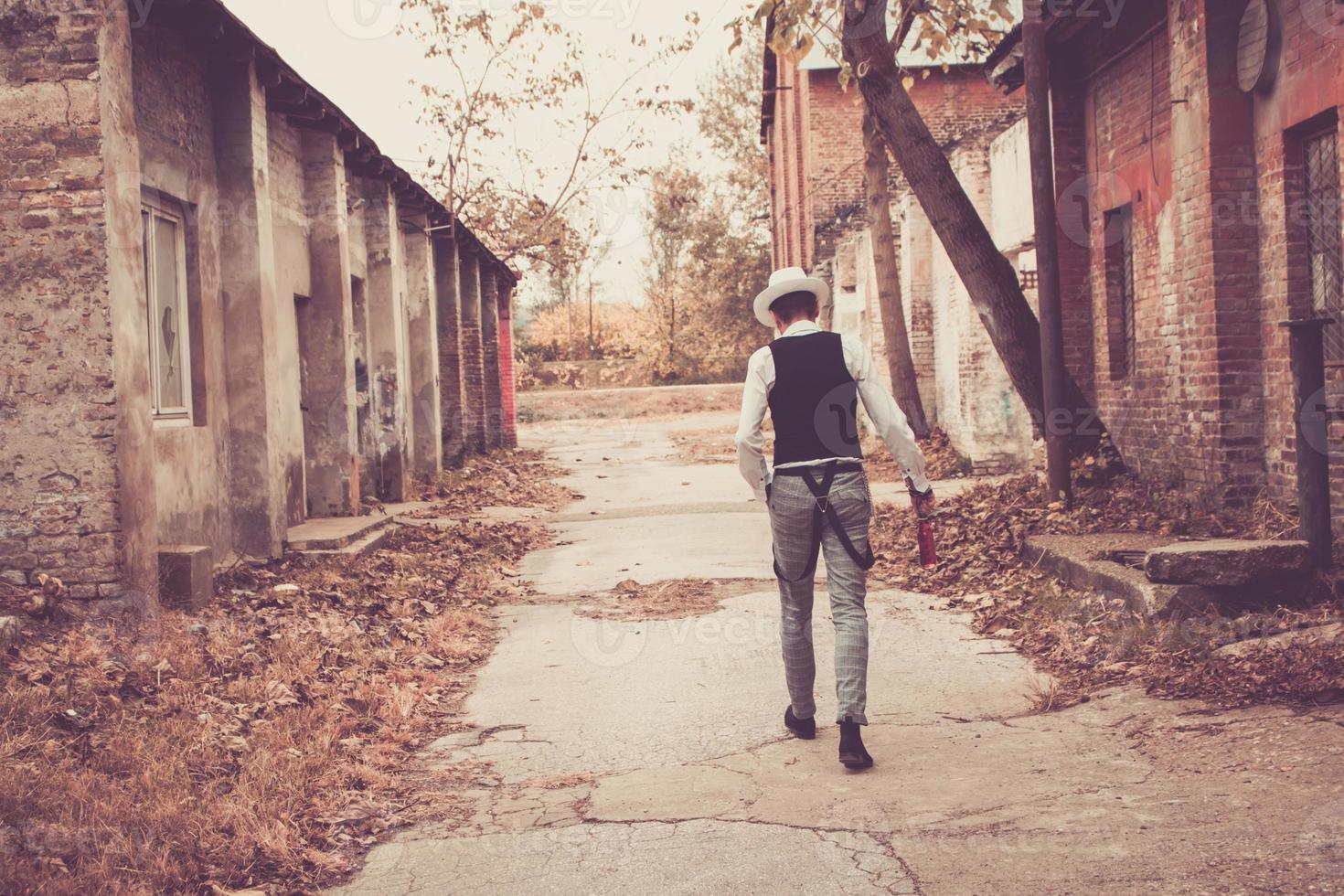 vista trasera de un hombre con estilo fedora caminando por la ciudad. foto