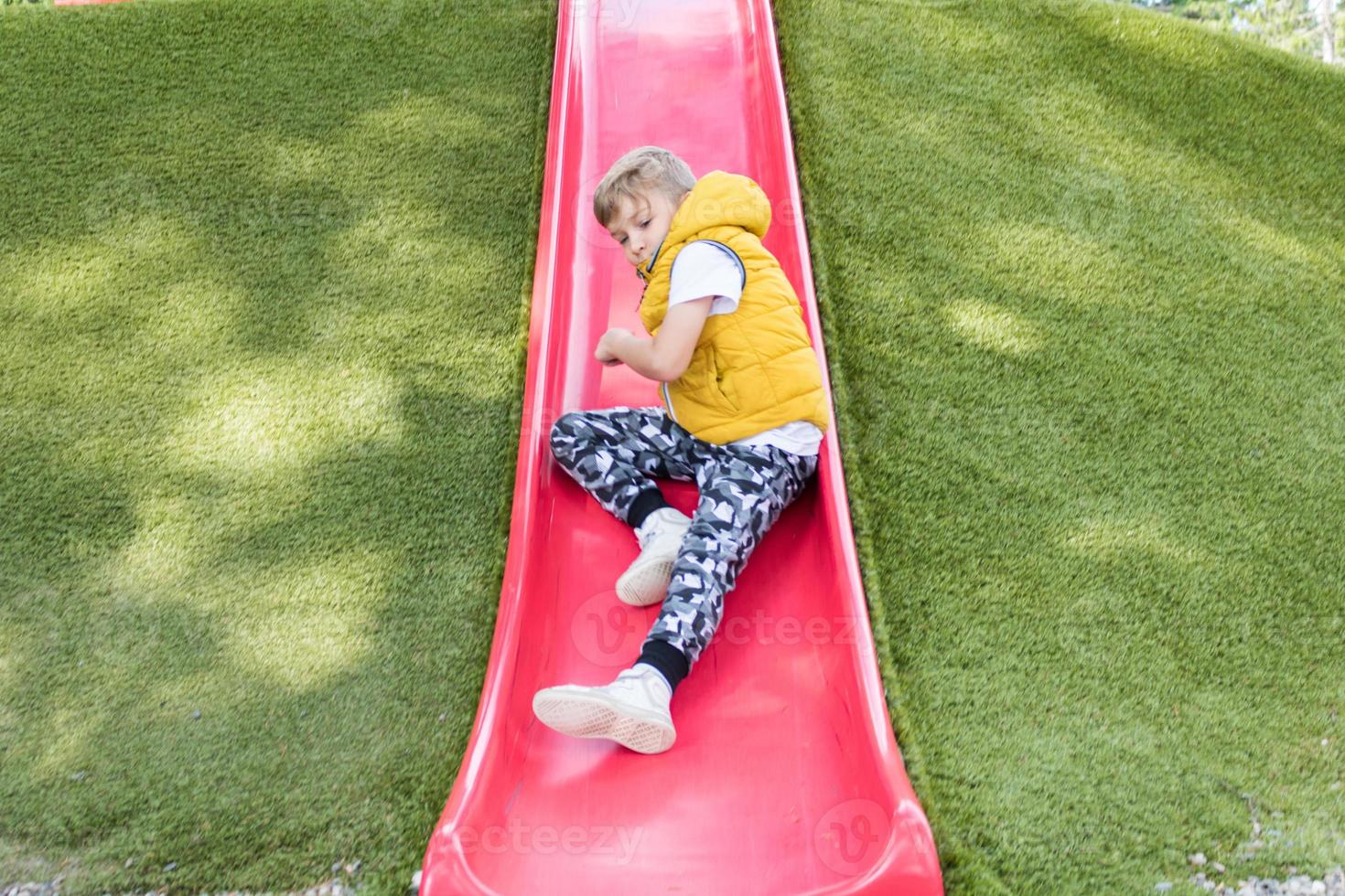 Kid sliding while spending a day in the park. photo