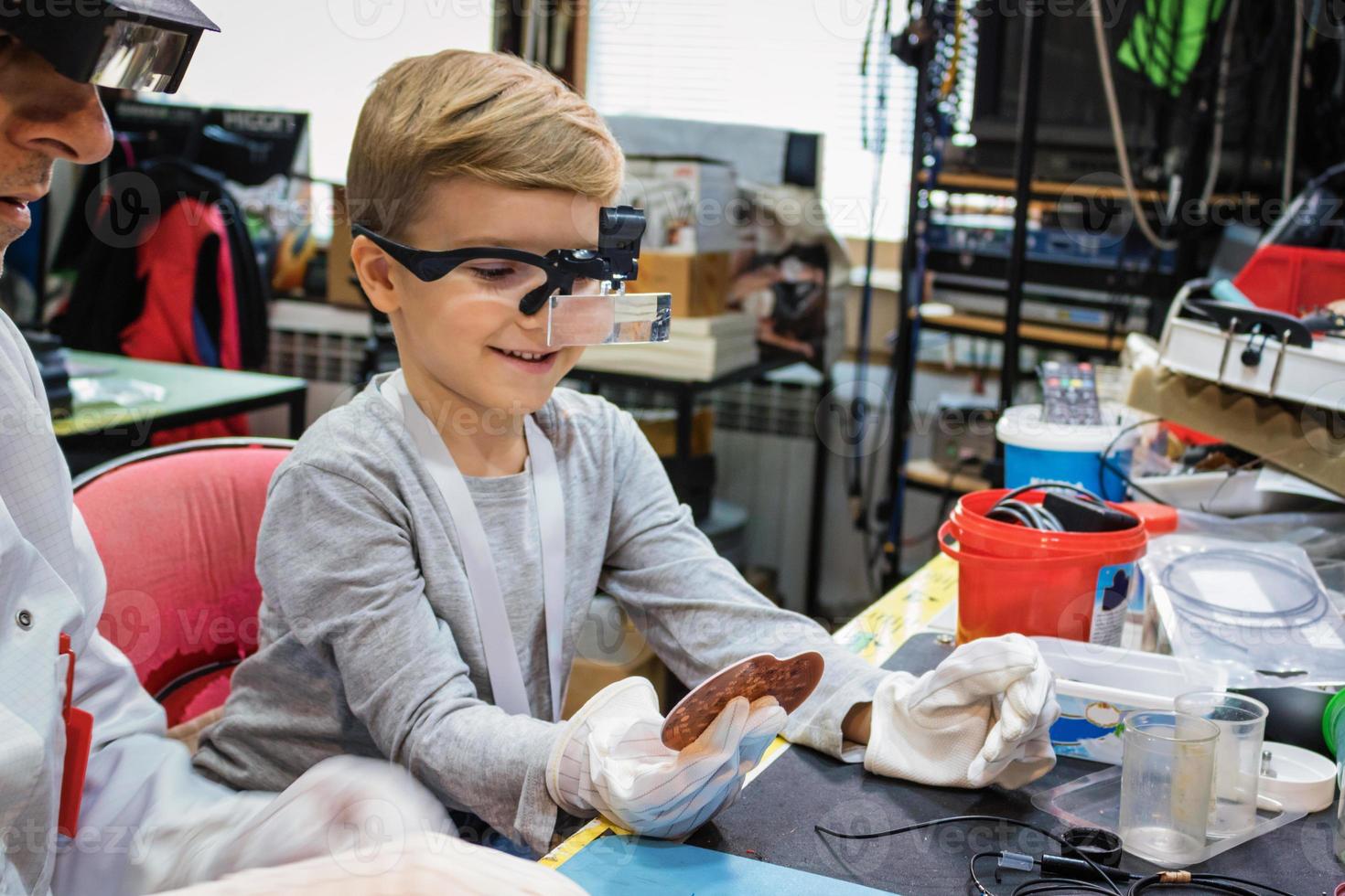 Happy boy examining computer part with IT teacher. photo