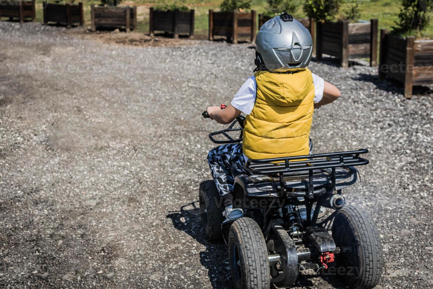 Little boy enjoying in off-road ride on atv vehicle. photo