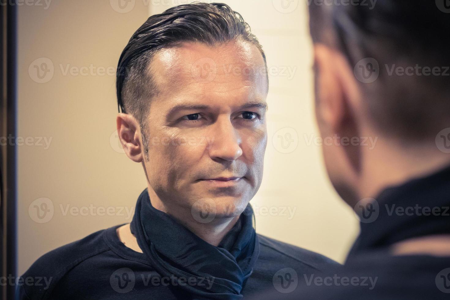Facing himself in mirror reflection. photo