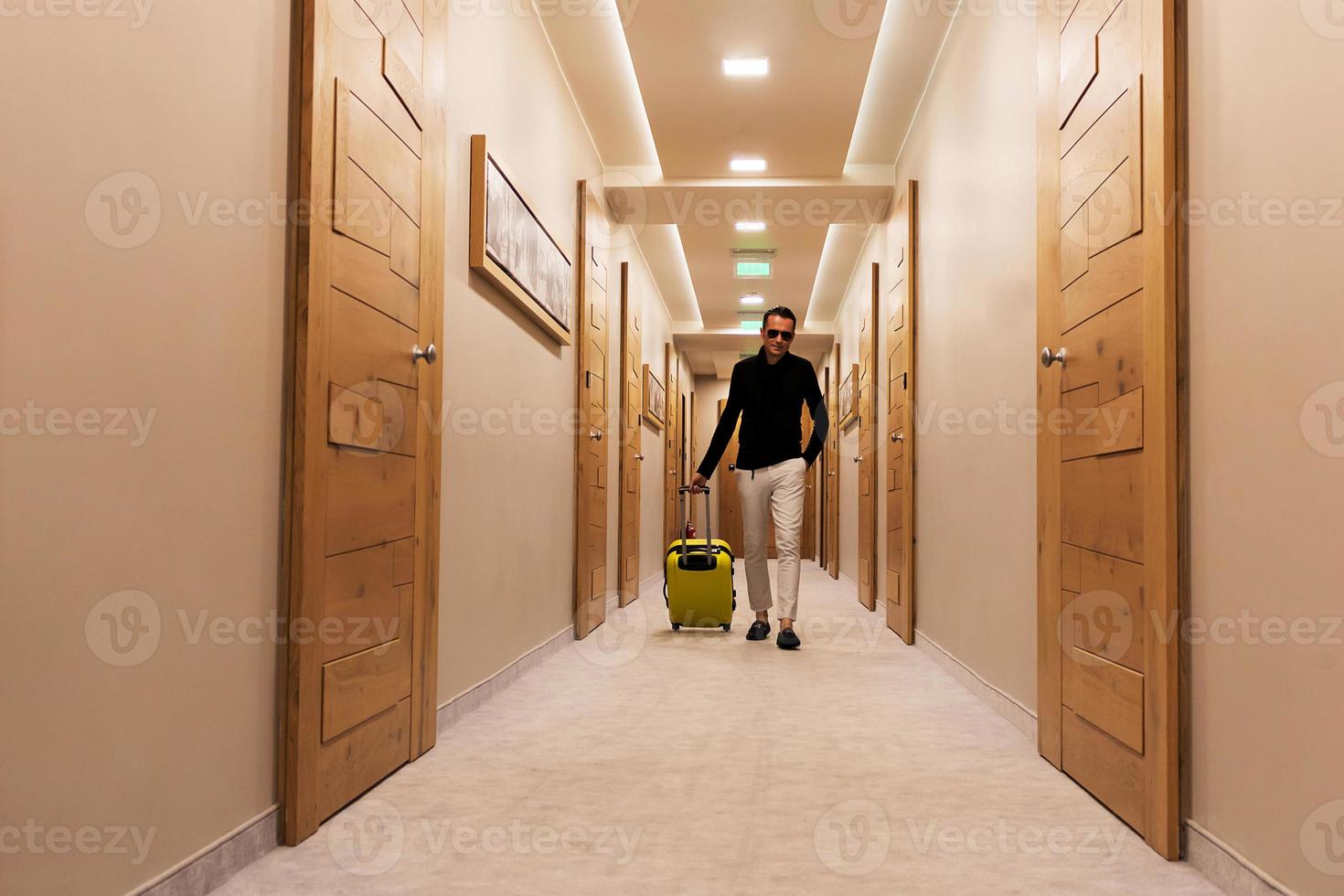 Man with travel bag walking through a hallway. photo