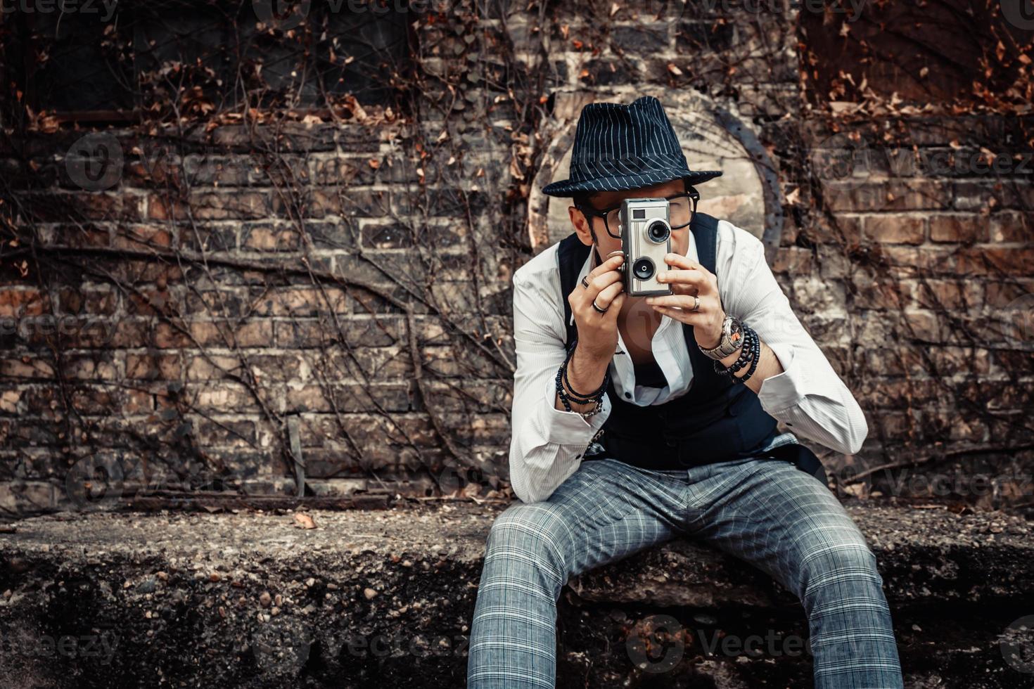 hombre de estilo retro filmando con una vieja cámara de video de 8 mm. foto