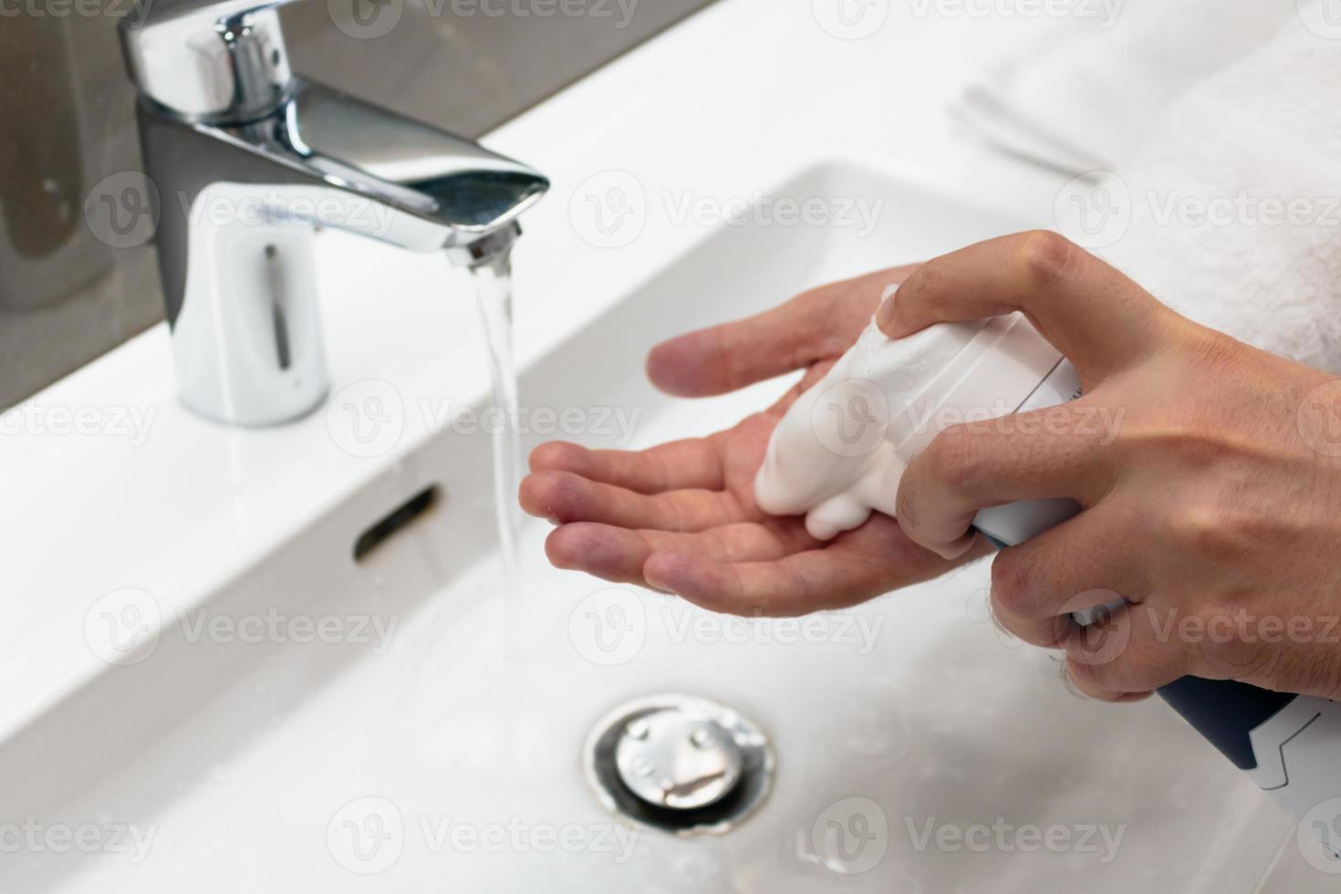 Man using shaving foam in the bathroom. photo