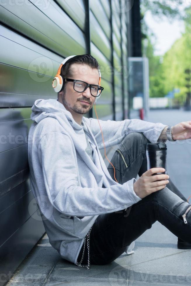 Freelance worker taking coffee break and listening music over headphones. photo