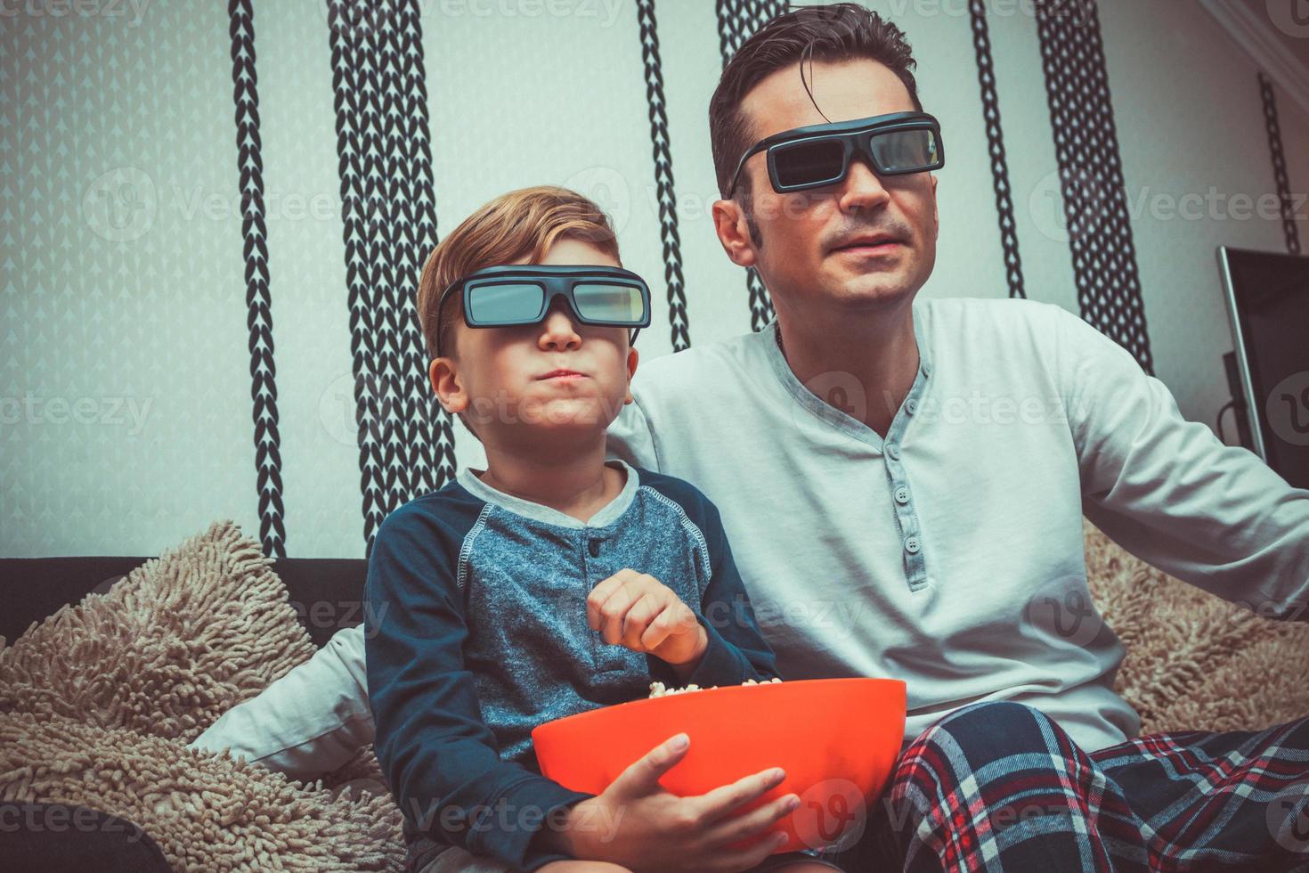 Father and son watching movie with 3D eyeglasses. photo