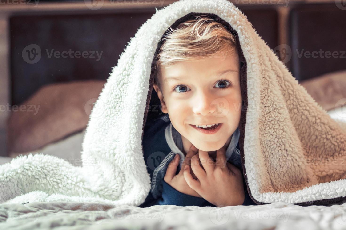 Happy kid under the blanket having fun in bed. 10909605 Stock Photo at Vecteezy