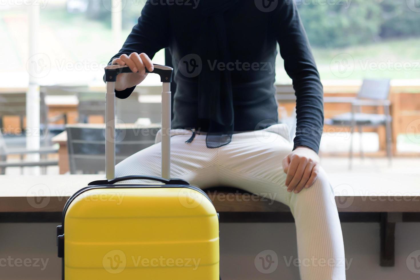 Unrecognizable man with suitcase in a hallway. photo